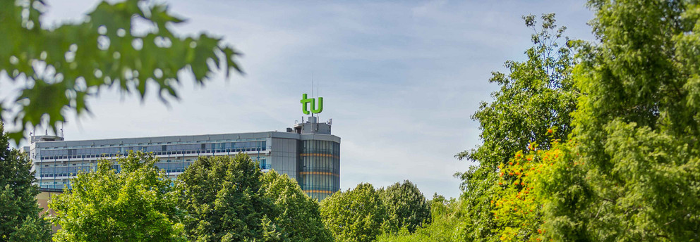 TU Dortmund im Sommer_01 Das Mathematikgebäude mit grünen Bäumen im Vordergrund.