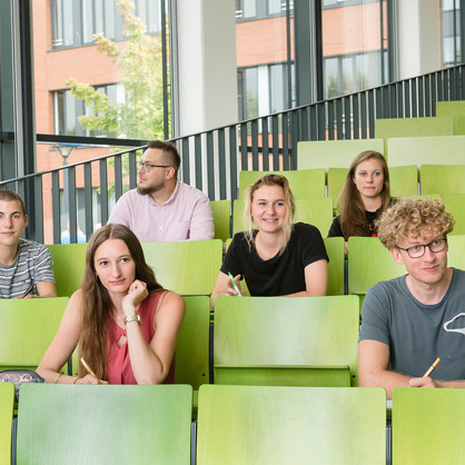 Gruppe Studierender im Hörsaal Eine Gruppe Studierender sitzt in einem Hörsaal.